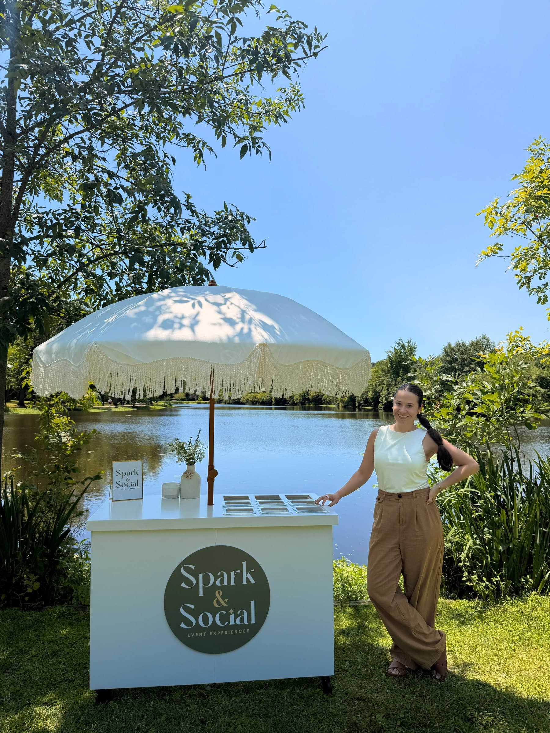 Camila, founder of Spark & Social, beside the signature event cart